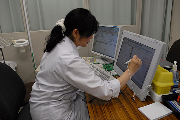 カルテを持ち電話をする女医 写真素材 [